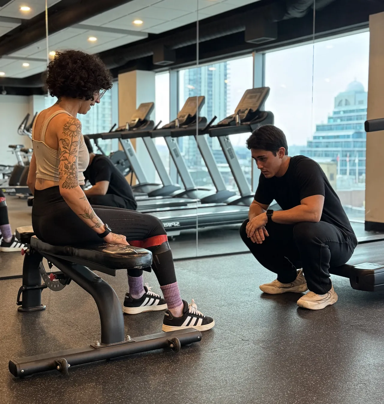 Guilherme, CanFitPRO certified personal trainer, coaching a client through a resistance band exercise