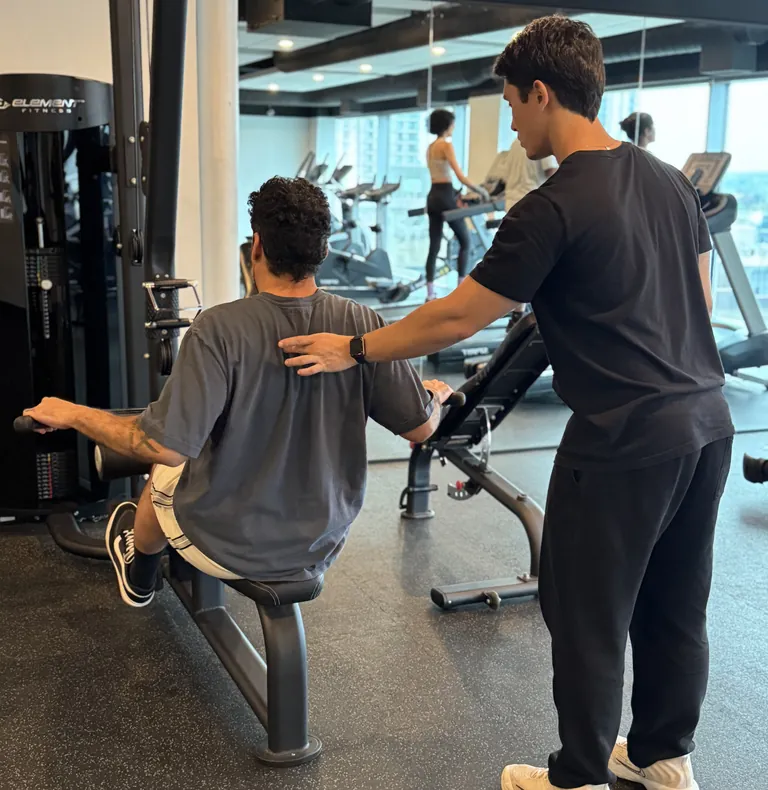 Guilherme adjusting a client’s posture with hands-on cues